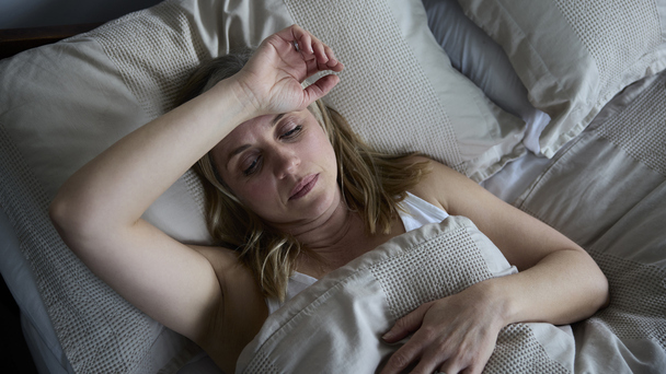 Mulher com calor noturno devido aos sintomas da menopausa.