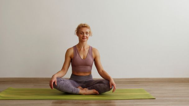 Mulher praticando yoga em posição de meditação 